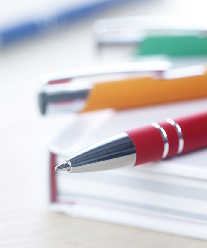 Penne in metallo in vari colori posate su di un libro